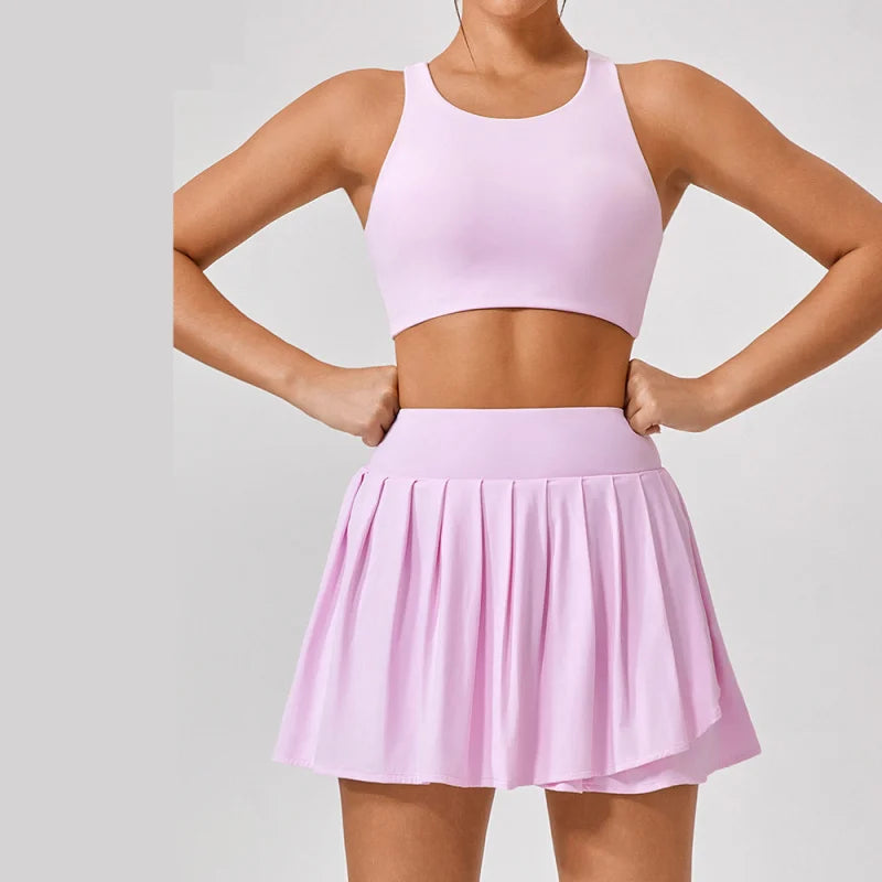 Luxury women’s tennis outfit featuring performance crop top, pleated tennis skirt and lightweight zip jacket, premium courtwear set designed for tennis and active lifestyle