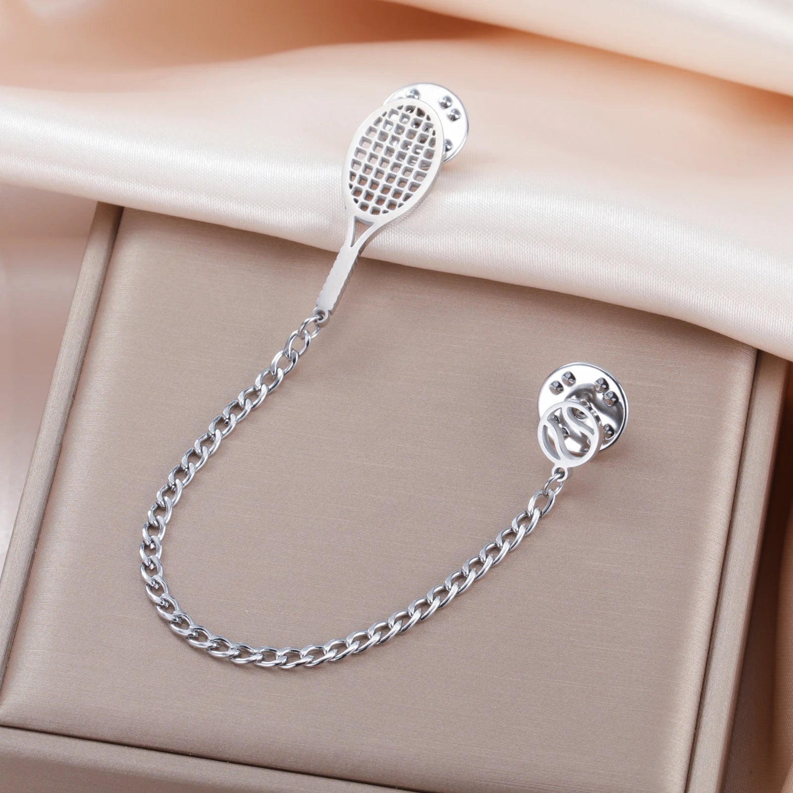 Minimal tennis-inspired lapel pin crafted for understated court elegance and polished everyday accessory styling
