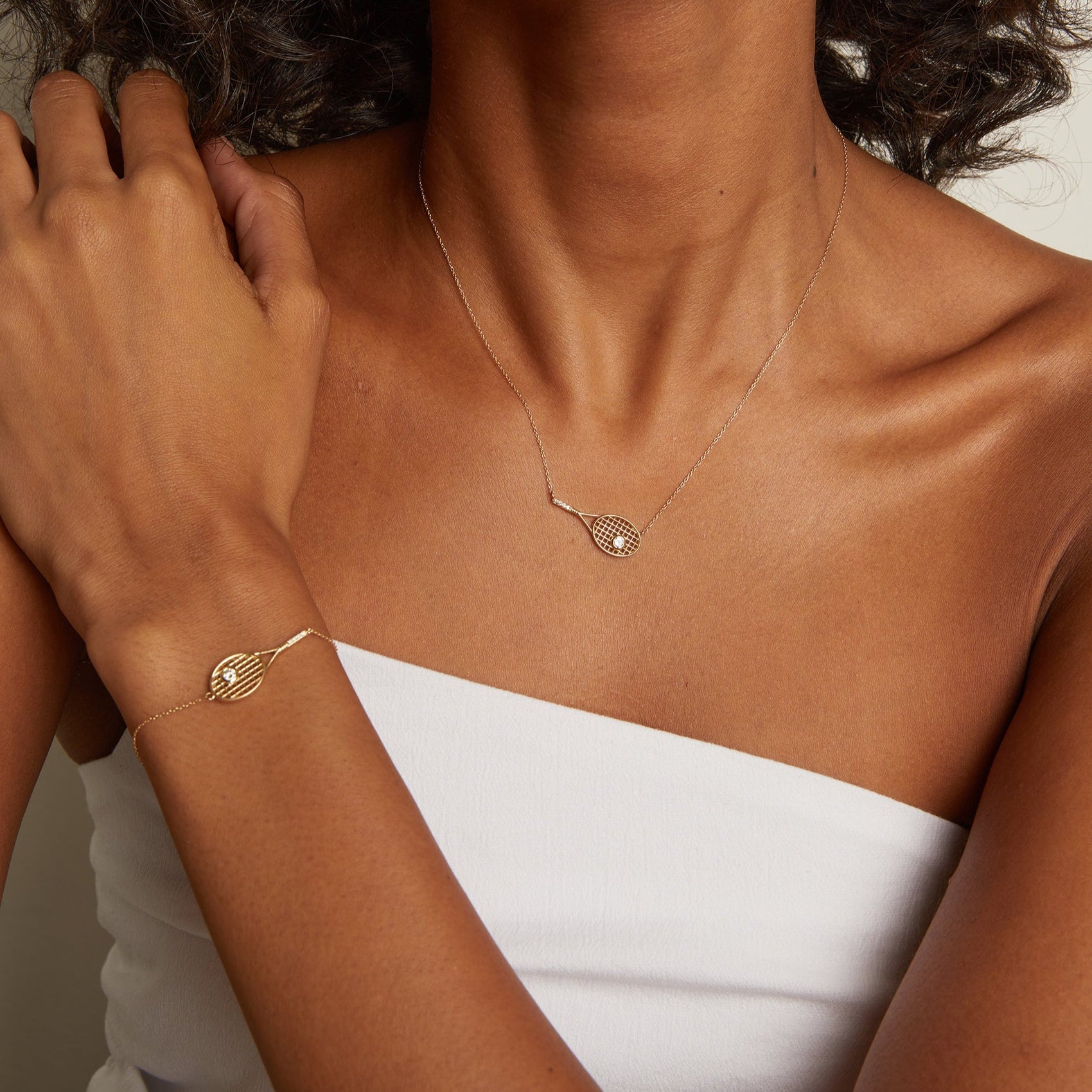 Minimal luxury racket bracelet featuring polished metal finish and brilliant white sapphire-inspired accents