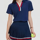 Premium women's pleated tennis dress styled on court with elegant athletic silhouette, performance fit, and modern country club aesthetic.