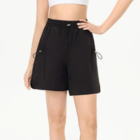 Elegant female tennis model showcasing premium athletic shorts on a modern outdoor tennis court.