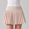 Female tennis model wearing premium tennis apparel with focus on the tennis skirt in a court setting
