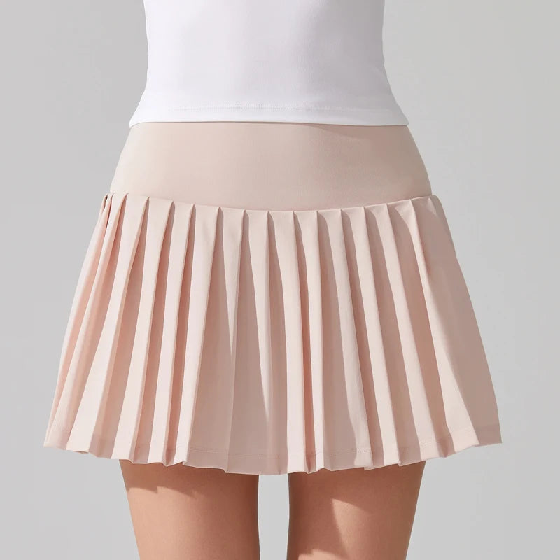 Female tennis model wearing premium tennis apparel with focus on the tennis skirt in a court setting