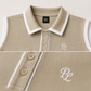Editorial close-up of premium tennis polo featuring structured collar, embroidered signature detail, precision stitching, and elevated athletic design.