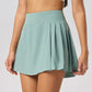 Female tennis player in premium courtwear featuring a performance tennis skirt designed for movement and sophistication