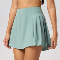 Female tennis player in premium courtwear featuring a performance tennis skirt designed for movement and sophistication