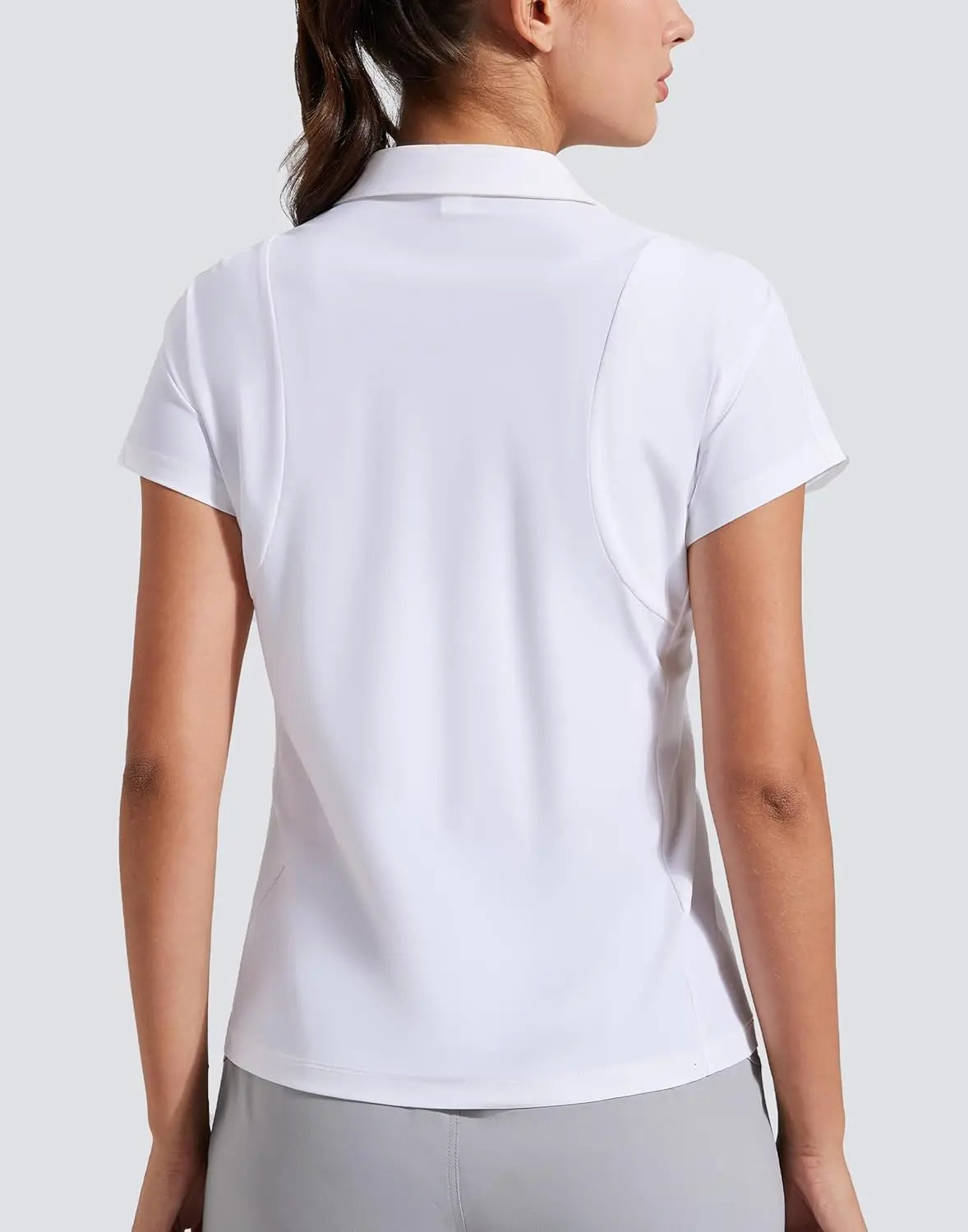 Female model showcasing premium tennis apparel in a neutral editorial studio portrait, blending classic court inspiration with modern everyday elegance.