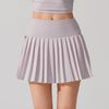 Tennis player in elegant athletic wear showcasing a pleated tennis skirt during court training