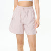 Female athlete wearing premium tennis shorts in a refined editorial sportswear look on court.